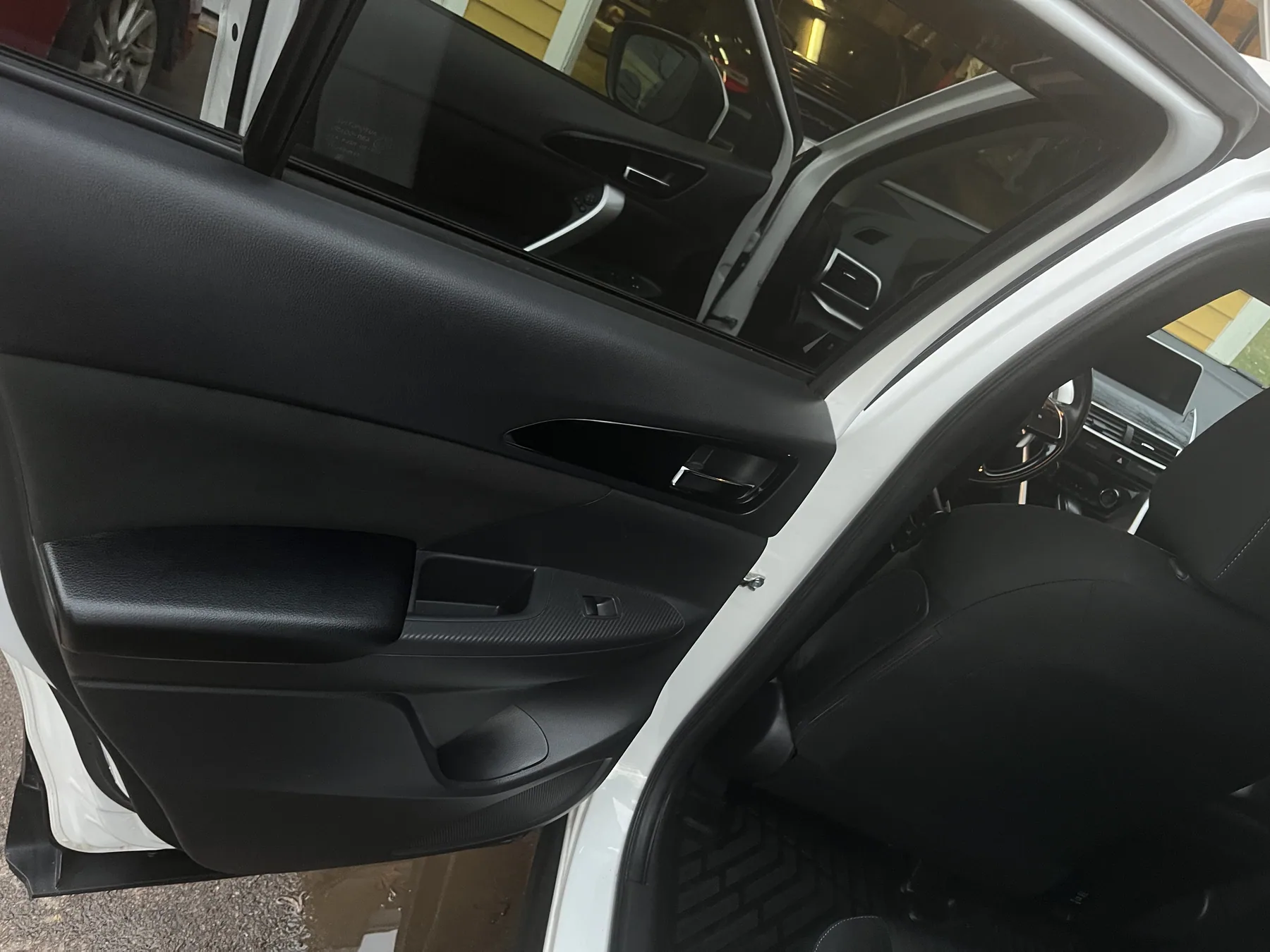 Detailed car interior viewed through an open rear door